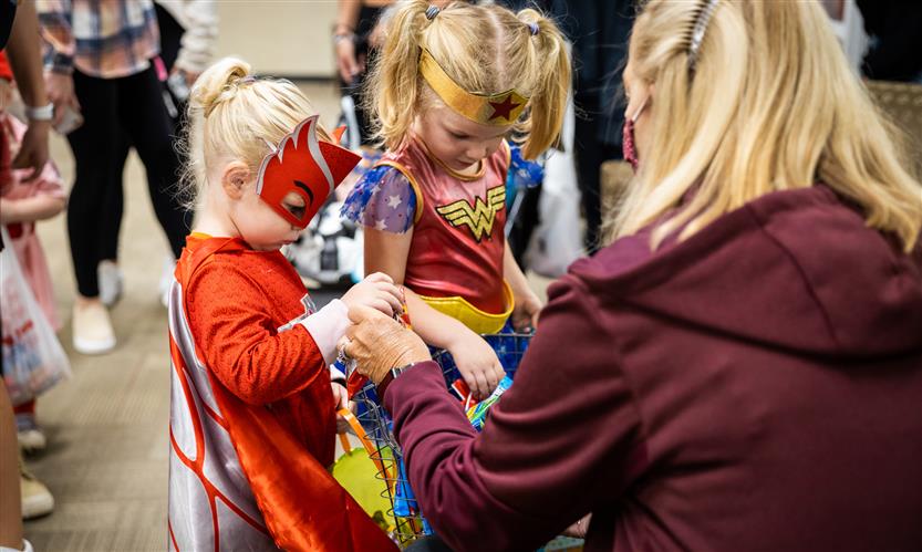 Children in costume trick or treat around school